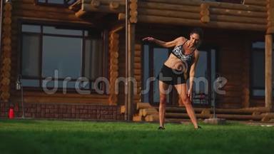 一位身材苗条、穿着运动服的漂亮女士正准备在她附近的草坪上开始训练
